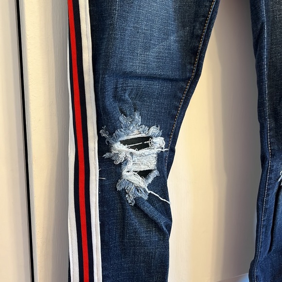 Dark blue jeans with rips by knees. Red, white & navy stripe detail along sides - Picture 2 of 3